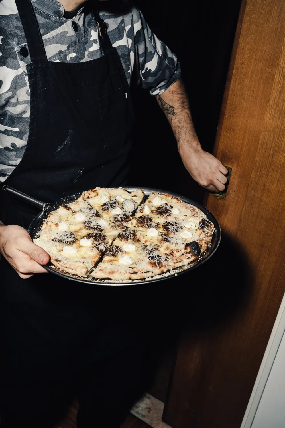 Chef presentando una pizza blanca