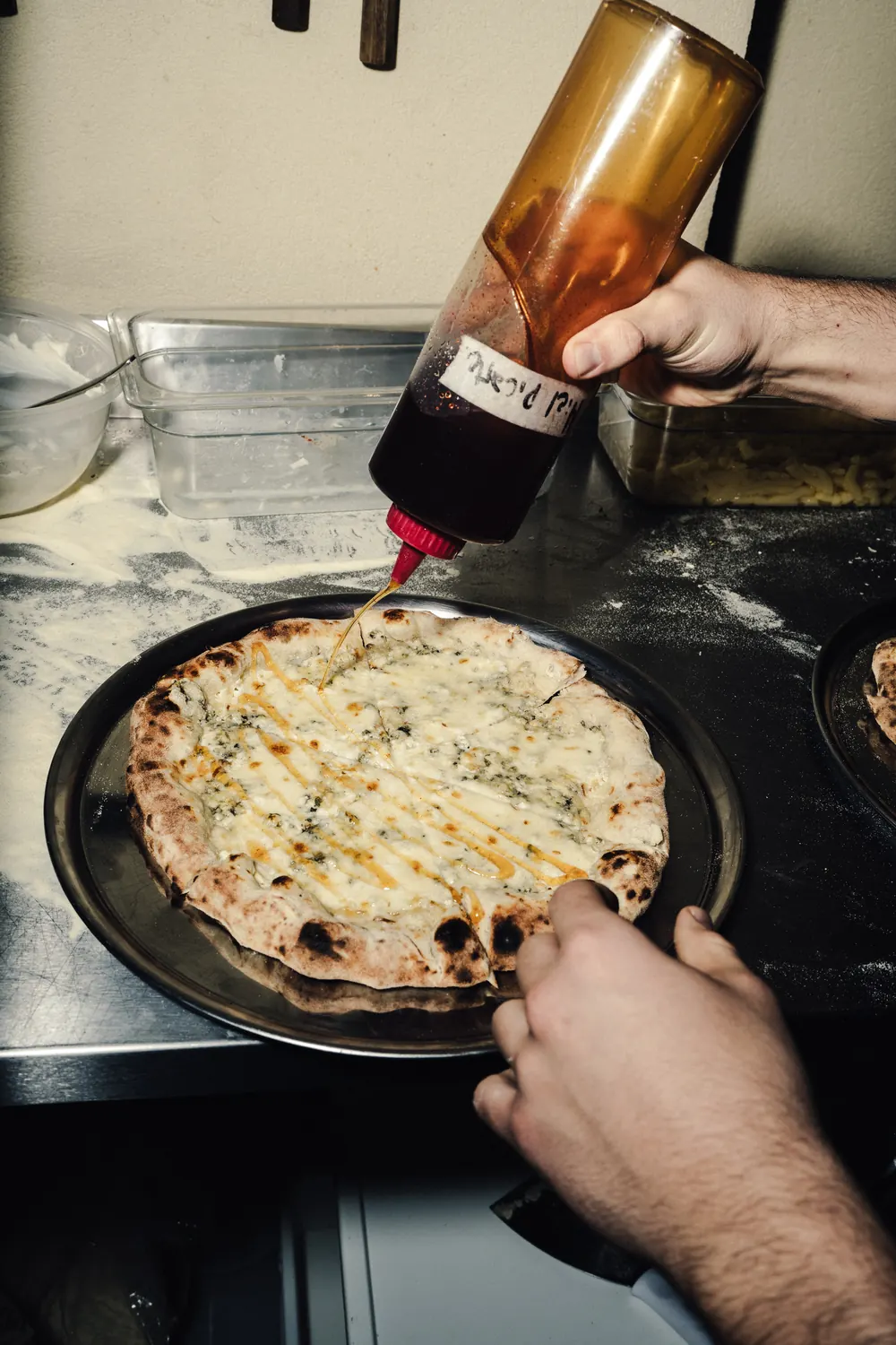 Miel picante sobre una pizza blanca con borde leopardo